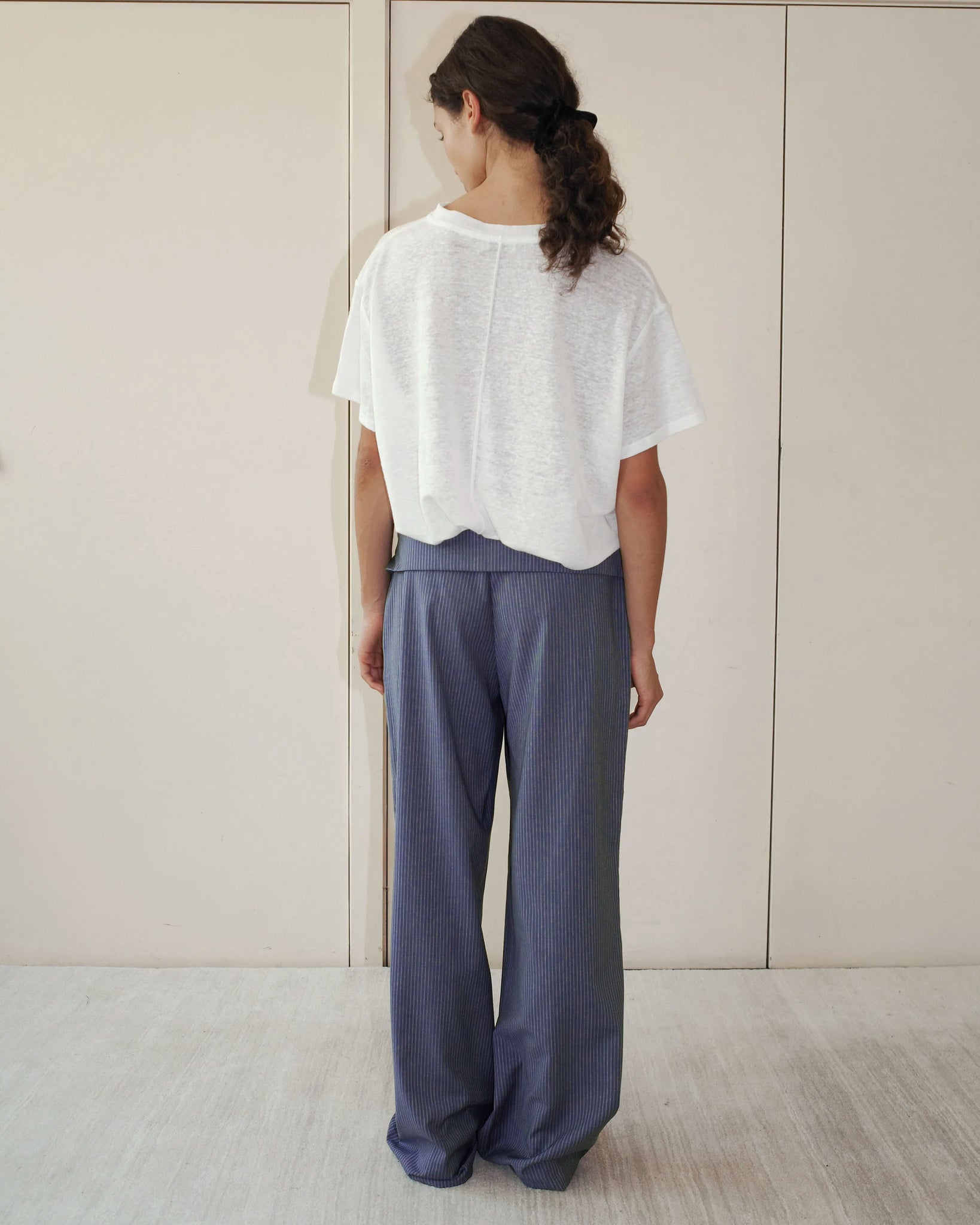 Model wearing the Deiji Studios Folded Wool Pant in Navy Stripe 