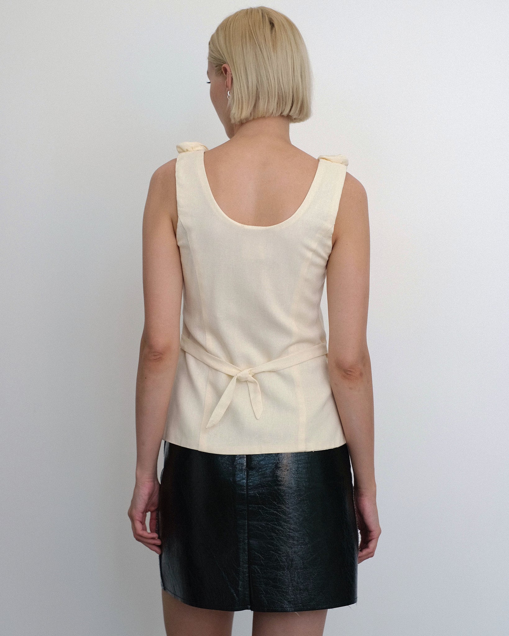 Model wearing the Loire vest top in ivory linen with floral embellished collar from Tach